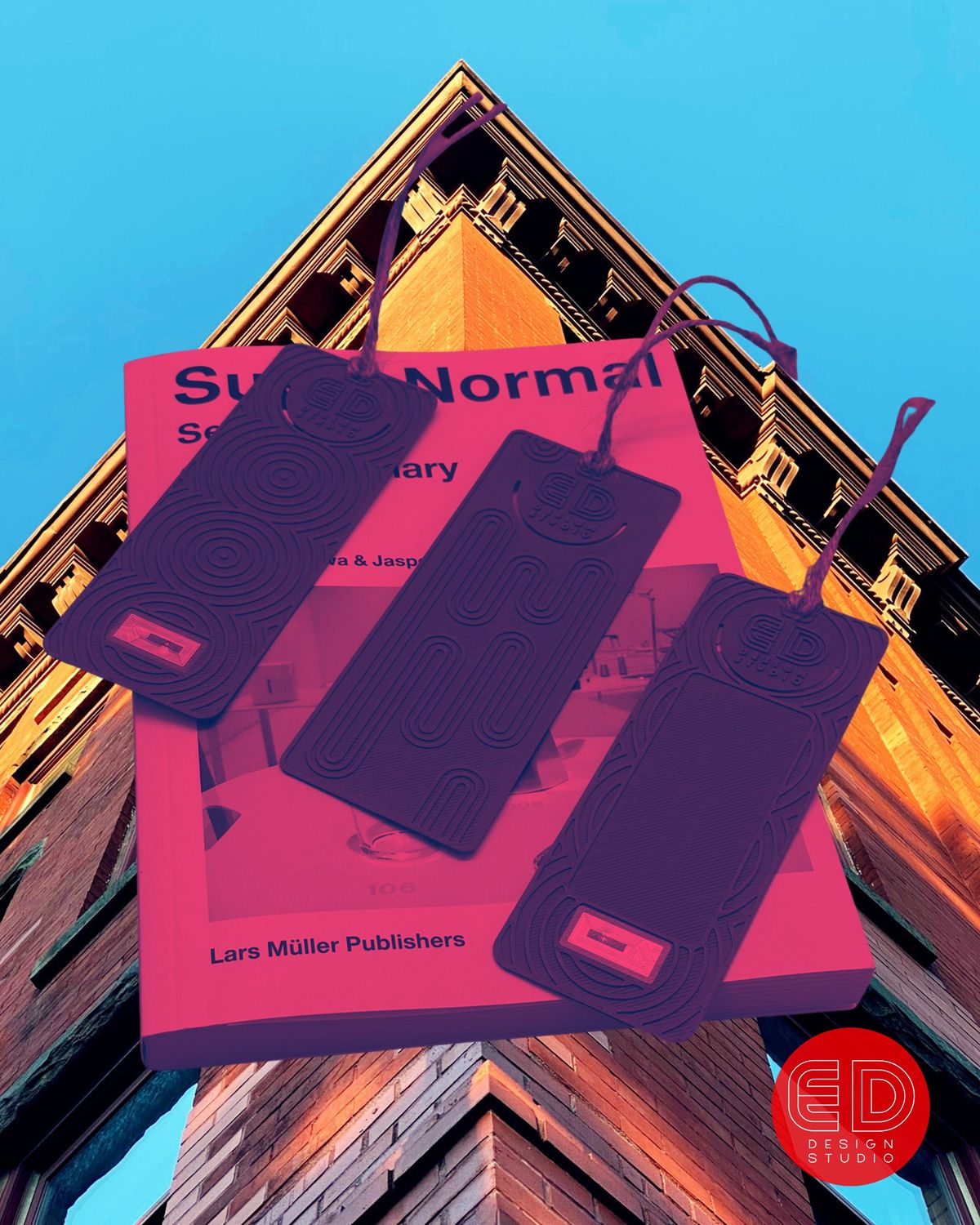 Three 3D-printed rectangular tags with embossed ED Design Studio logos and raised line patterns, resting on a book
